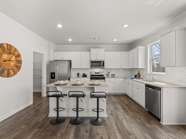 kitchen featuring white cabinets, sink, dark hardwood / wood-style floors, ornamental molding, and appliances with stainless steel finishes