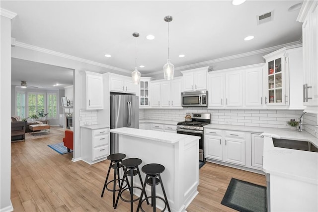 5710 Waters Edge Trl, Roswell, GA 30075 - kitchen with appliances with stainless steel finishes, a center island, a kitchen breakfast bar, white cabinetry, and recessed lighting