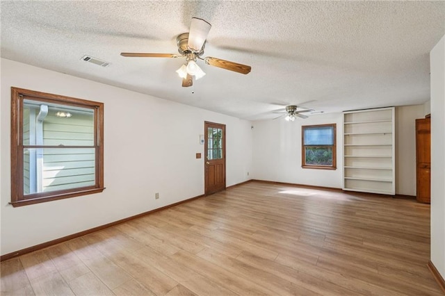 2110 Waterloo Cir, Lawrenceville, GA 30043 - spare room featuring a textured ceiling, a ceiling fan, light wood-type flooring, and built in features
