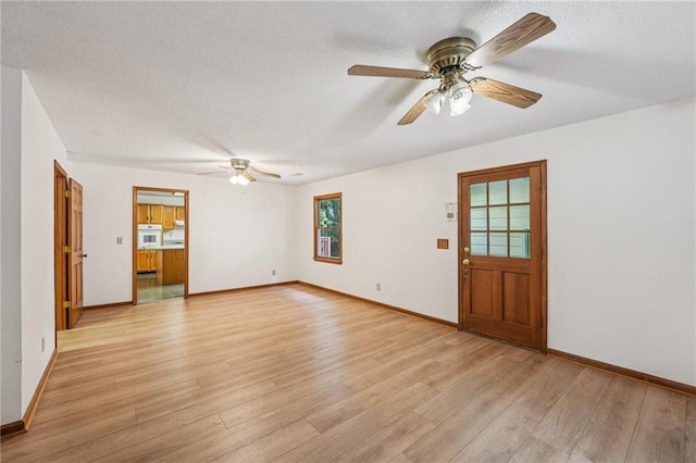 2110 Waterloo Cir, Lawrenceville, GA 30043 - unfurnished living room featuring a ceiling fan, light wood-style floors, a textured ceiling, and plenty of natural light