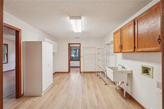 2110 Waterloo Cir, Lawrenceville, GA 30043 - laundry room featuring cabinet space, hookup for a washing machine, light wood-type flooring, and a textured ceiling