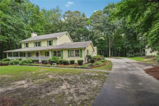 2110 Waterloo Cir, Lawrenceville, GA 30043 - view of front facade with asphalt driveway, a chimney, covered porch, and a front lawn