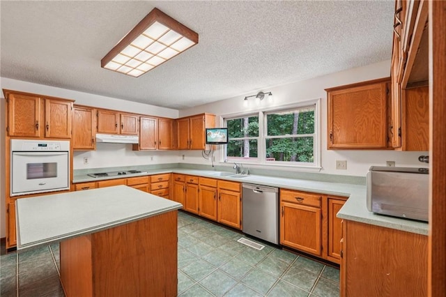 2110 Waterloo Cir, Lawrenceville, GA 30043 - kitchen with oven, dishwasher, a textured ceiling, light countertops, and under cabinet range hood