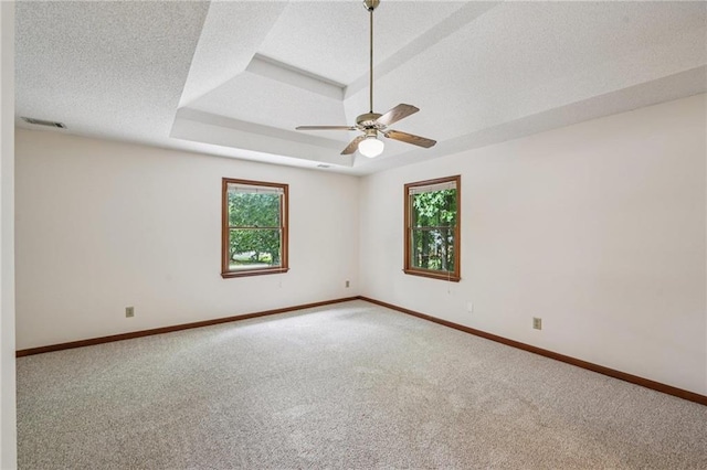 2110 Waterloo Cir, Lawrenceville, GA 30043 - empty room featuring plenty of natural light, carpet, a ceiling fan, a textured ceiling, and a tray ceiling
