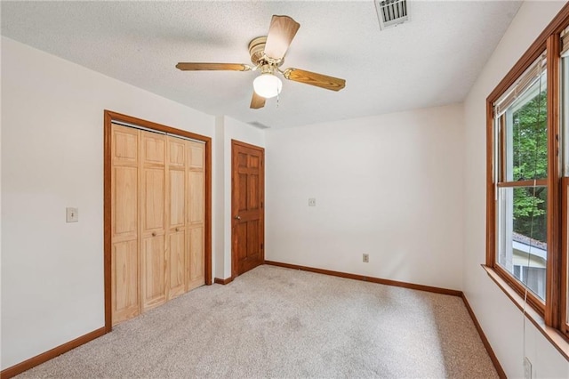 2110 Waterloo Cir, Lawrenceville, GA 30043 - unfurnished bedroom featuring light colored carpet, a closet, a ceiling fan, and a textured ceiling