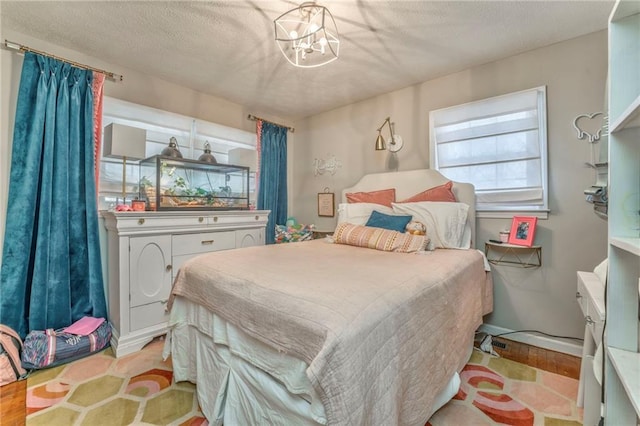 bedroom with a notable chandelier and a textured ceiling