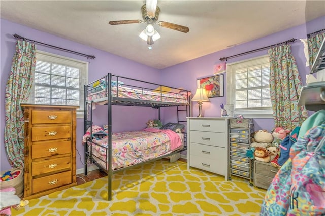 bedroom with ceiling fan and multiple windows