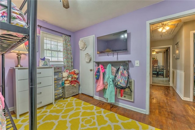 bedroom with heating unit and hardwood / wood-style floors