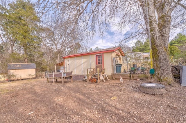 rear view of house featuring a storage shed