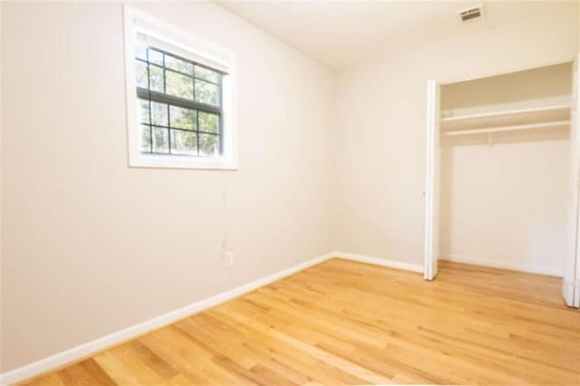 unfurnished bedroom with visible vents, baseboards, light wood-type flooring, and a closet