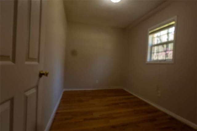 unfurnished room with baseboards and wood finished floors