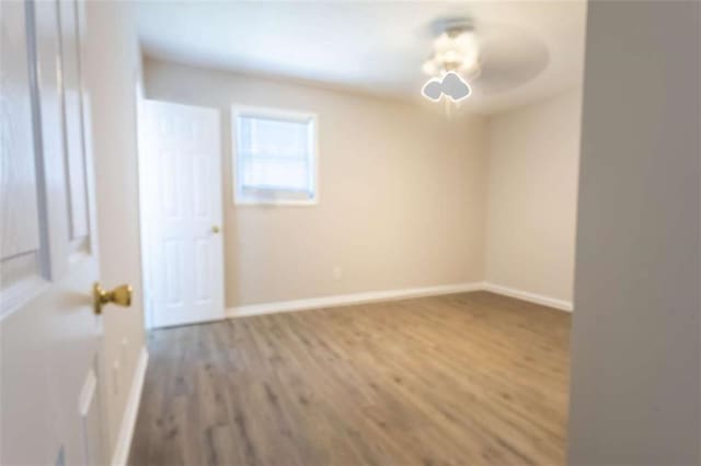 unfurnished room featuring a ceiling fan, wood finished floors, and baseboards