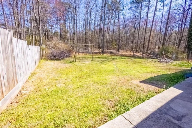 view of yard featuring fence and a view of trees