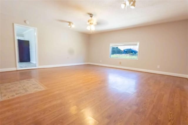 unfurnished room with baseboards and wood finished floors