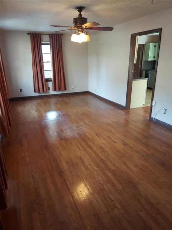 empty room featuring ceiling fan and dark hardwood / wood-style flooring