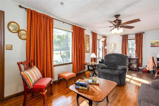 living room featuring hardwood / wood-style floors, a textured ceiling, and ceiling fan