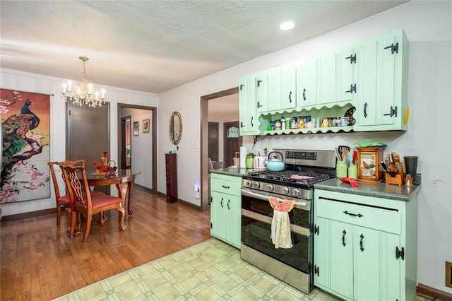 kitchen with range with two ovens, green cabinets, a textured ceiling, an inviting chandelier, and light hardwood / wood-style flooring