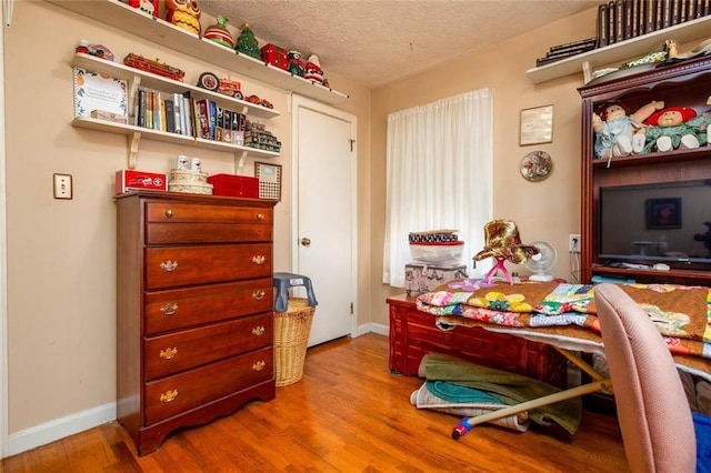 home office with hardwood / wood-style flooring and a textured ceiling