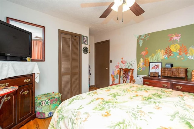 bedroom with light hardwood / wood-style floors, a closet, and ceiling fan