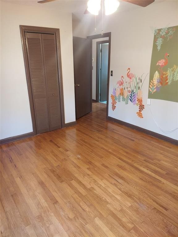 unfurnished bedroom with ceiling fan, a closet, and light wood-type flooring