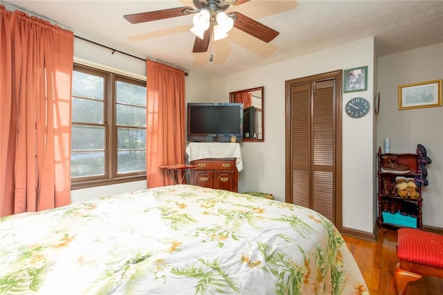 bedroom featuring light hardwood / wood-style flooring, ceiling fan, and a closet