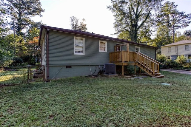 rear view of property with a wooden deck, a lawn, and central air condition unit