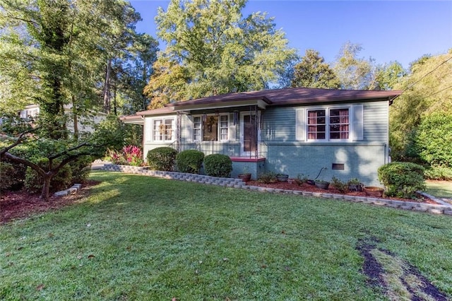 ranch-style house with a front yard and covered porch