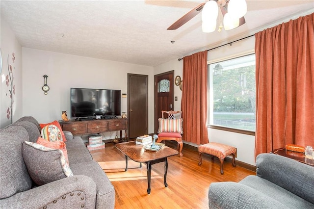 living room featuring ceiling fan, hardwood / wood-style flooring, and a textured ceiling