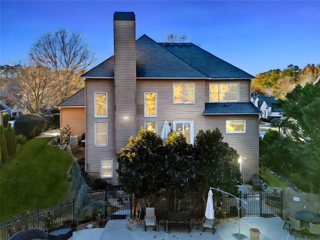 back of property with a patio area, a yard, and central AC