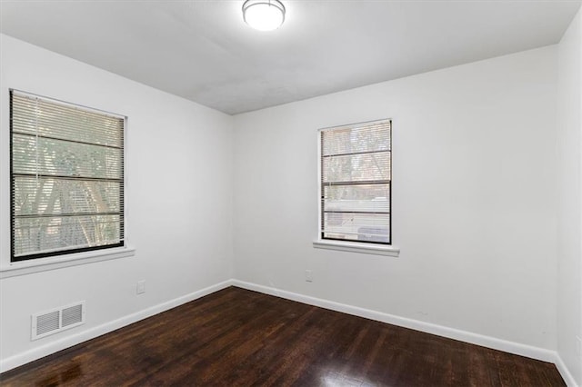 unfurnished room with dark hardwood / wood-style flooring