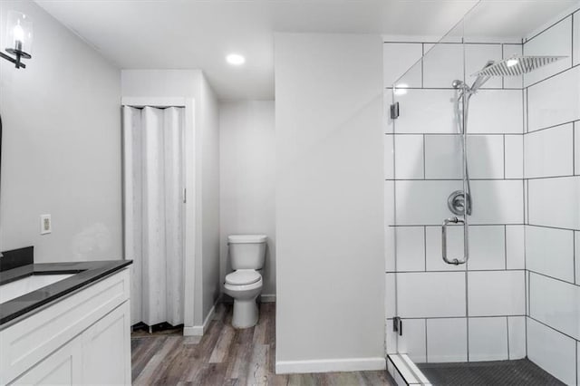 bathroom with hardwood / wood-style flooring, vanity, toilet, and a shower with shower door