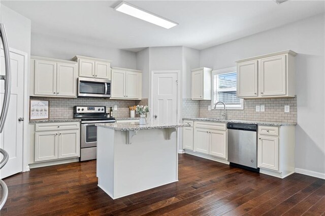 306 Springwater Way, Bremen, GA 30110 - kitchen featuring stainless steel appliances, dark wood-type flooring, light stone counters, backsplash, and a breakfast bar