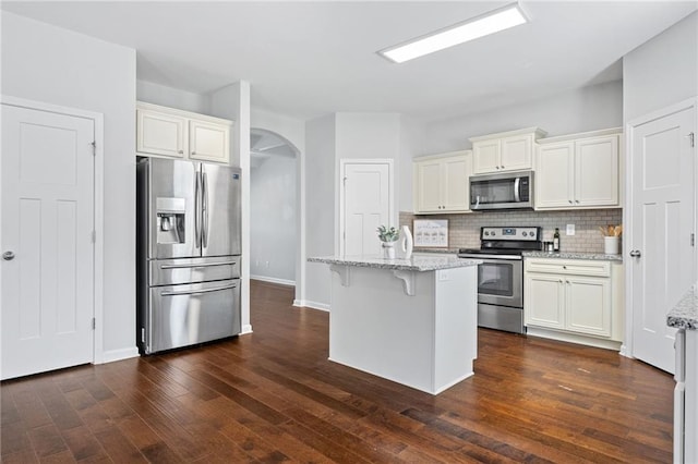 306 Springwater Way, Bremen, GA 30110 - kitchen with stainless steel appliances, arched walkways, white cabinets, and backsplash