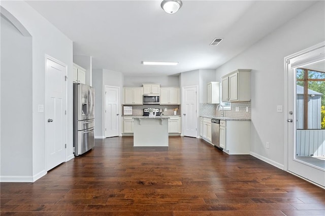 306 Springwater Way, Bremen, GA 30110 - kitchen featuring stainless steel appliances, dark wood-style floors, backsplash, a kitchen island, and arched walkways