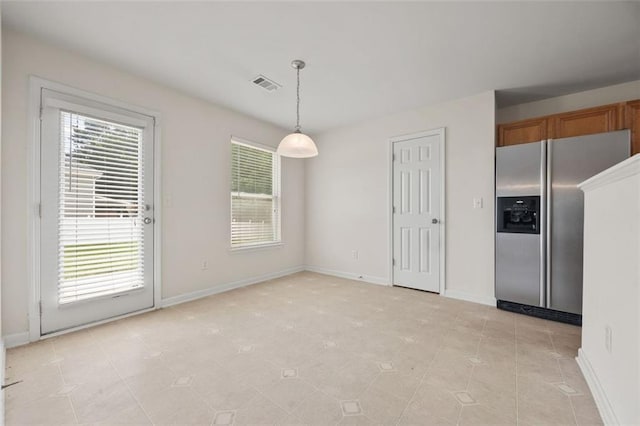 unfurnished dining area with baseboards and light tile patterned flooring