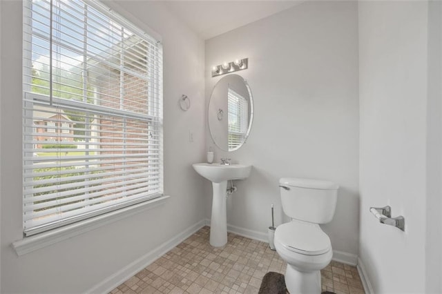 bathroom with toilet and baseboards