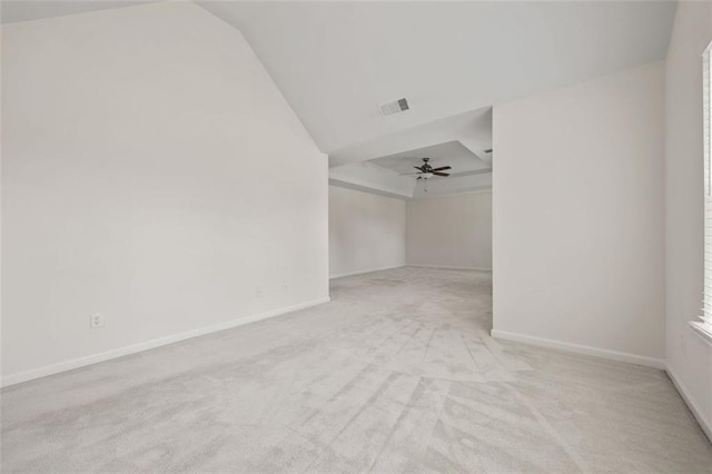 empty room featuring carpet, ceiling fan, lofted ceiling, and baseboards