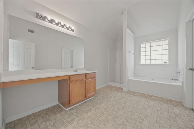 full bathroom with vanity, a garden tub, a shower stall, lofted ceiling, and baseboards
