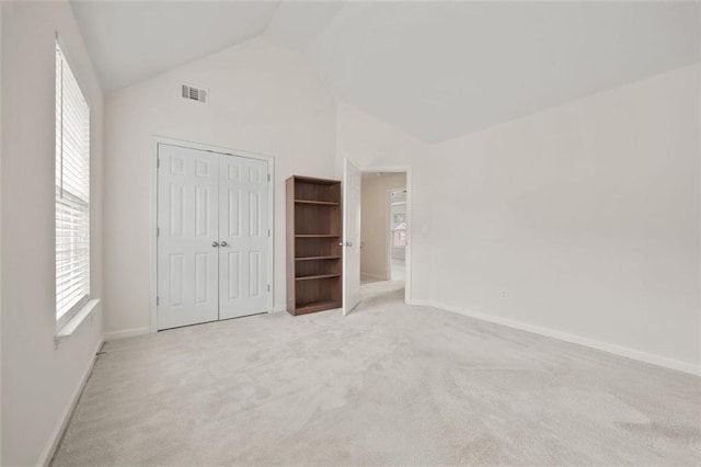 unfurnished bedroom with vaulted ceiling, carpet floors, baseboards, and a closet