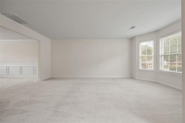 additional living space with light colored carpet and a decorative wall
