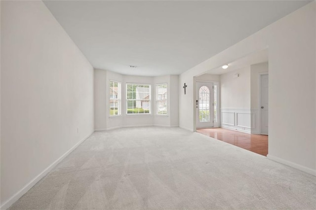 spare room featuring carpet floors and baseboards