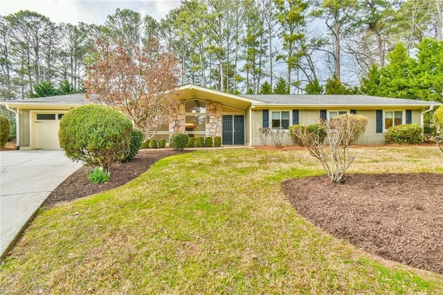 view of front facade with an attached garage, stone siding, a front lawn, and concrete driveway