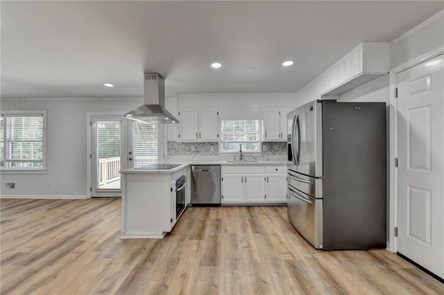 kitchen featuring white cabinetry, stainless steel appliances, wall chimney range hood, and light wood-type flooring