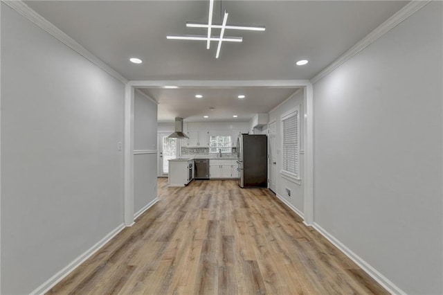 unfurnished living room with sink, crown molding, and light hardwood / wood-style floors