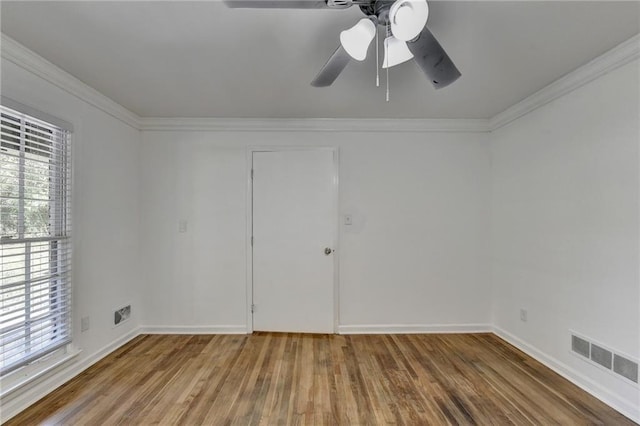 empty room with ceiling fan, hardwood / wood-style flooring, and ornamental molding