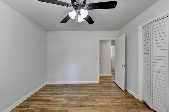 unfurnished bedroom with light hardwood / wood-style flooring, a closet, and ceiling fan