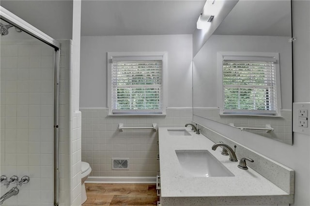 bathroom with vanity, toilet, tile walls, and hardwood / wood-style floors