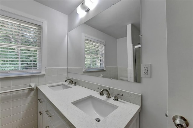 bathroom with vanity, tile walls, a wealth of natural light, and walk in shower