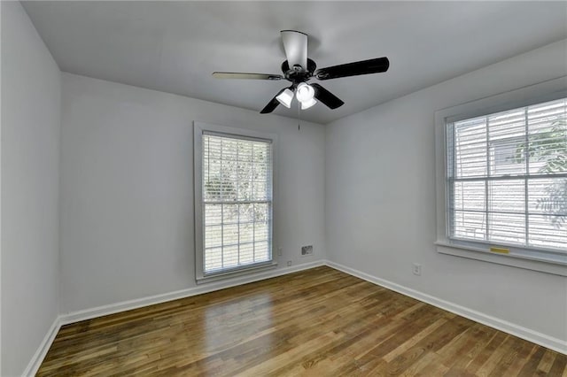 empty room with ceiling fan, hardwood / wood-style flooring, and plenty of natural light