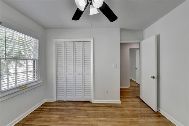 unfurnished bedroom with light hardwood / wood-style floors, a closet, and ceiling fan